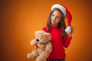 Image showing The cute cheerful little girl on orange background