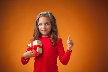 Image showing The cute cheerful little girl on orange background