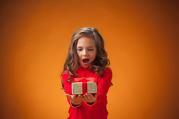 Image showing The cute cheerful little girl on orange background