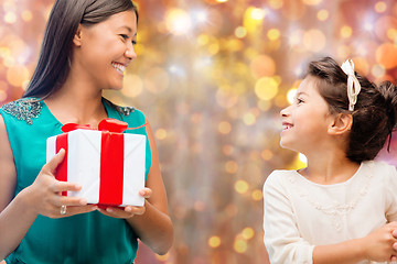 Image showing happy mother and girl with gift box over lights