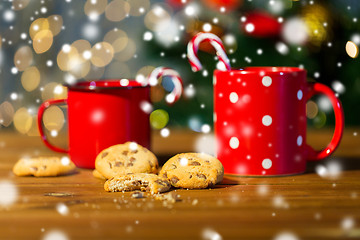 Image showing christmas candy canes and cups on wooden table