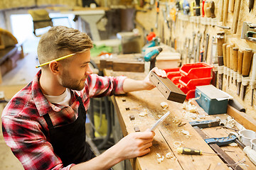 Image showing carpenter working with wood plank at workshop