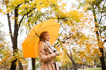 Image showing happy woman with umbrella walking in autumn park