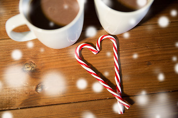 Image showing christmas candy canes and cups on wooden table