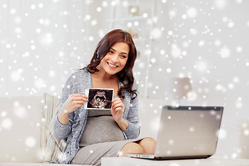 Image showing pregnant woman with ultrasound image and laptop