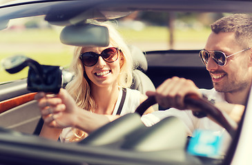 Image showing happy couple usin gps navigation system in car