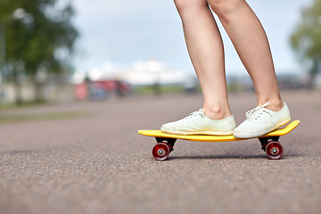 Image showing close up of female feet riding short skateboard