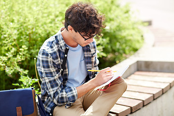 Image showing man with notebook or diary writing on city street