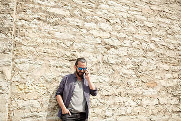 Image showing smiling man with smartphone calling on city street