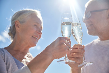 Image showing happy senior couple drinking champagne outdoors