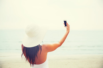 Image showing smiling young woman taking selfie with smartphone