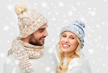 Image showing smiling couple in winter clothes hugging over snow