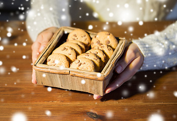 Image showing close up of woman with oat cookies at home