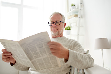 Image showing senior man in glasses reading newspaper at home