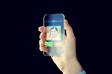 Image showing close up of male hand with transparent smartphone