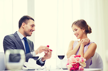 Image showing man proposing to his girlfriend at restaurant