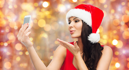 Image showing woman in santa hat taking selfie by smartphone