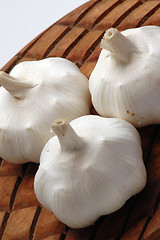 Image showing three garlic on wood