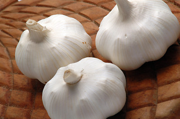 Image showing three garlic on woode