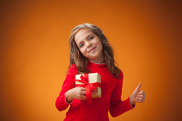 Image showing The cute cheerful little girl on orange background