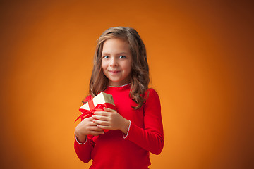 Image showing The cute cheerful little girl on orange background