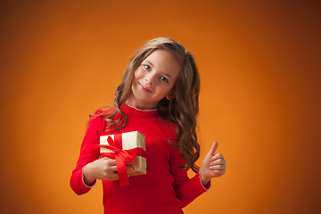 Image showing The cute cheerful little girl on orange background