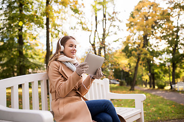 Image showing woman with tablet pc and headphones in autumn park