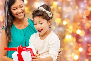 Image showing happy mother and girl with gift box over lights