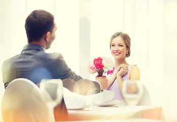 Image showing smiling woman recieving bouquet of flowers