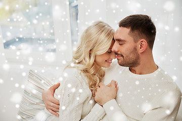 Image showing happy couple covered with plaid on sofa at home