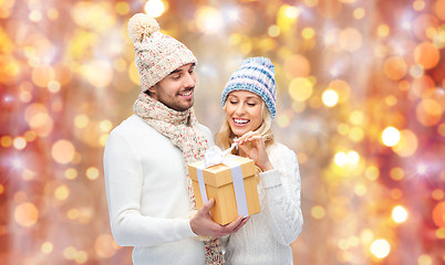 Image showing smiling couple in winter clothes with gift box