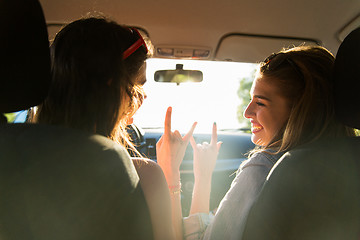 Image showing happy teenage girls or women driving in car