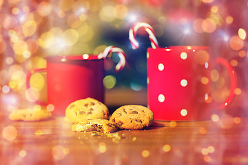 Image showing christmas candy canes and cups on wooden table