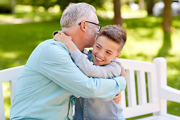 Image showing grandfather and grandson hugging at summer park