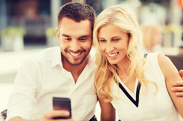 Image showing happy couple with smatphone at city street cafe