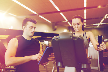 Image showing woman with trainer exercising on stepper in gym