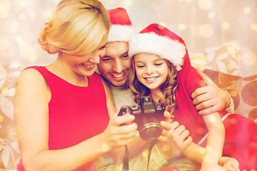 Image showing family in santa helper hats looking at pictires