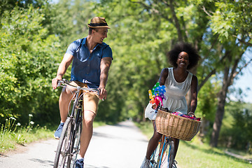 Image showing Young multiethnic couple having a bike ride in nature