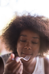 Image showing a young African American woman eating pasta