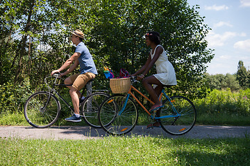 Image showing Young multiethnic couple having a bike ride in nature