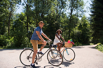 Image showing Young multiethnic couple having a bike ride in nature