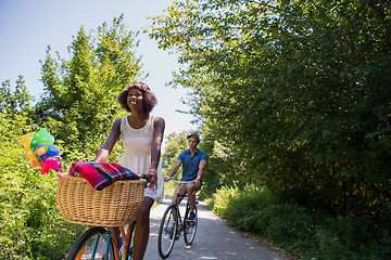 Image showing Young multiethnic couple having a bike ride in nature