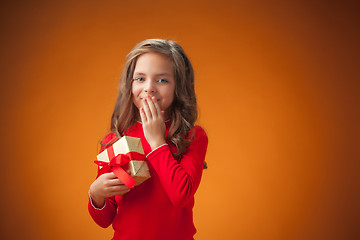 Image showing The cute cheerful little girl on orange background