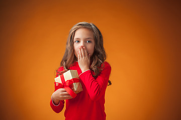 Image showing The cute cheerful little girl on orange background