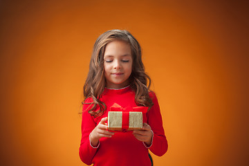 Image showing The cute cheerful little girl on orange background