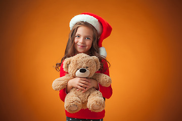 Image showing The cute cheerful little girl on orange background