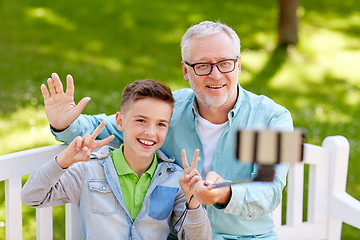 Image showing old man and boy taking selfie by smartphone