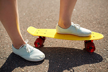 Image showing close up of female feet riding short skateboard