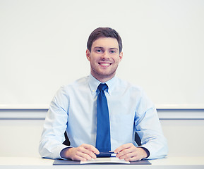 Image showing smiling businessman sitting in office