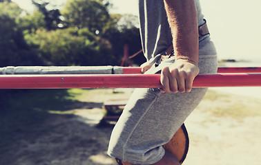 Image showing young man exercising on parallel bars outdoors